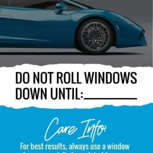 A blue sports car with a mirror hanger displaying a 'Do Not Roll Windows Down Until' reminder and tint care instructions.